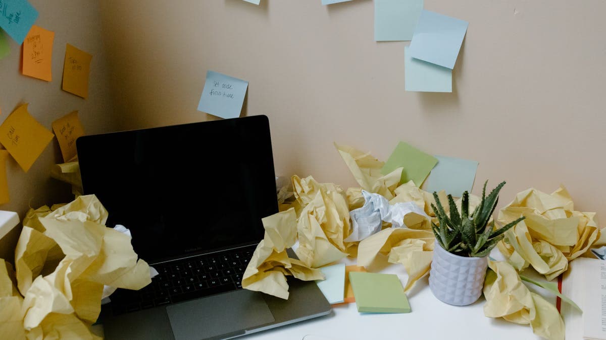An overflowing email inbox on a screen beside a notepad of unsorted property orders