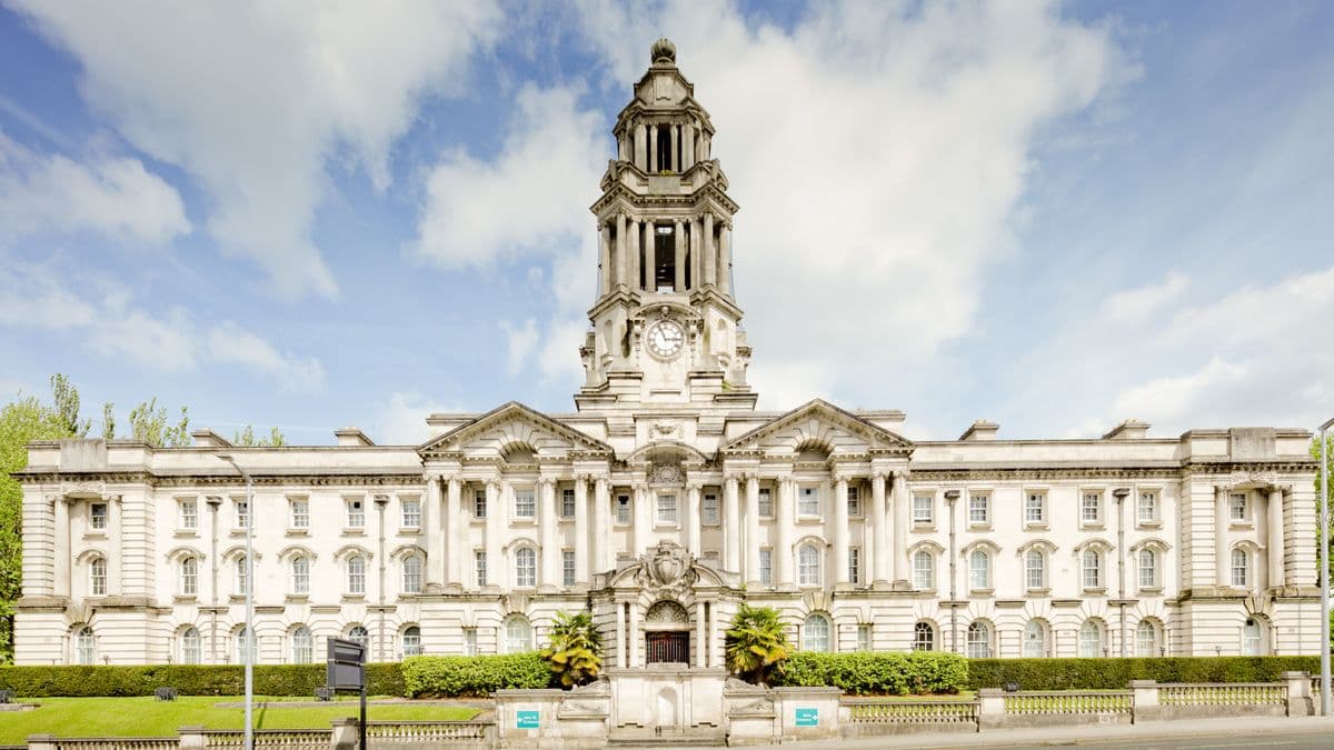 Map of England and Wales council boundaries with search firm screens in background