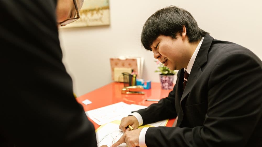 Conveyancer reviewing a checklist of search provider criteria at a desk